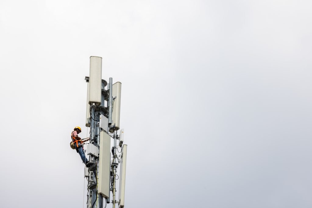 A technician works on a telecommunications tower.